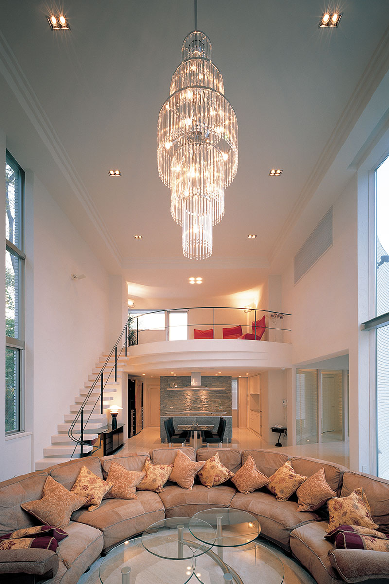 高い天井に豪華なシャンデリアが輝く広々とした吹き抜けのリビング